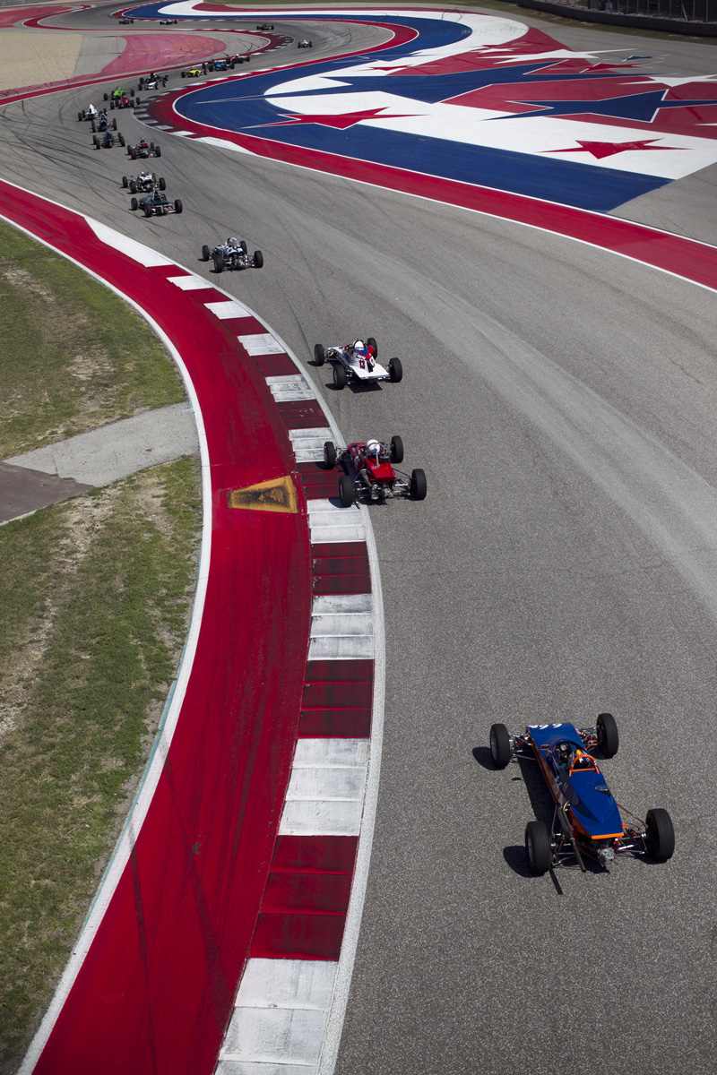 A line of vintage Formula Fords through a sweeping corner
